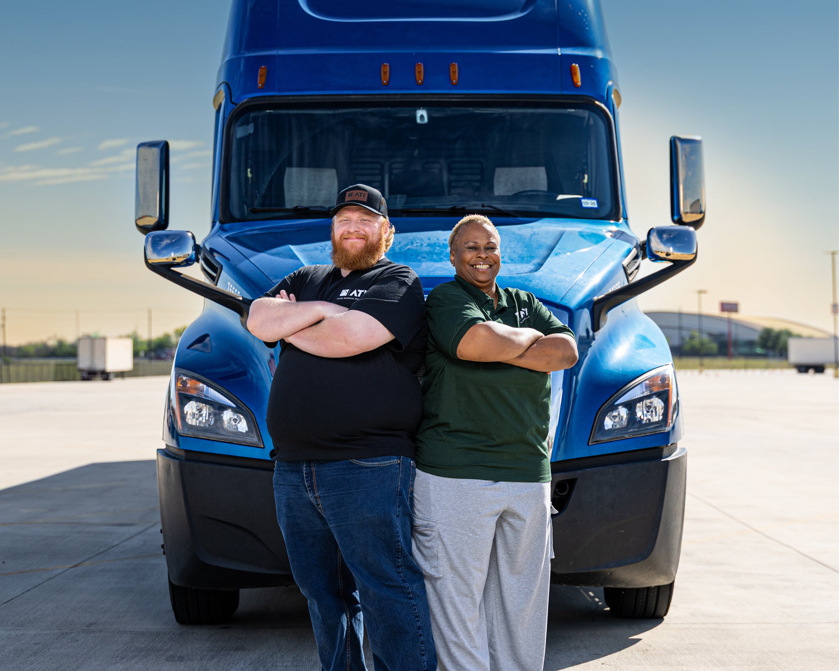Male student and female instructor standing in front of 18 wheeler