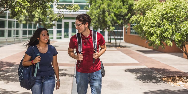 Male and female student walking on campus