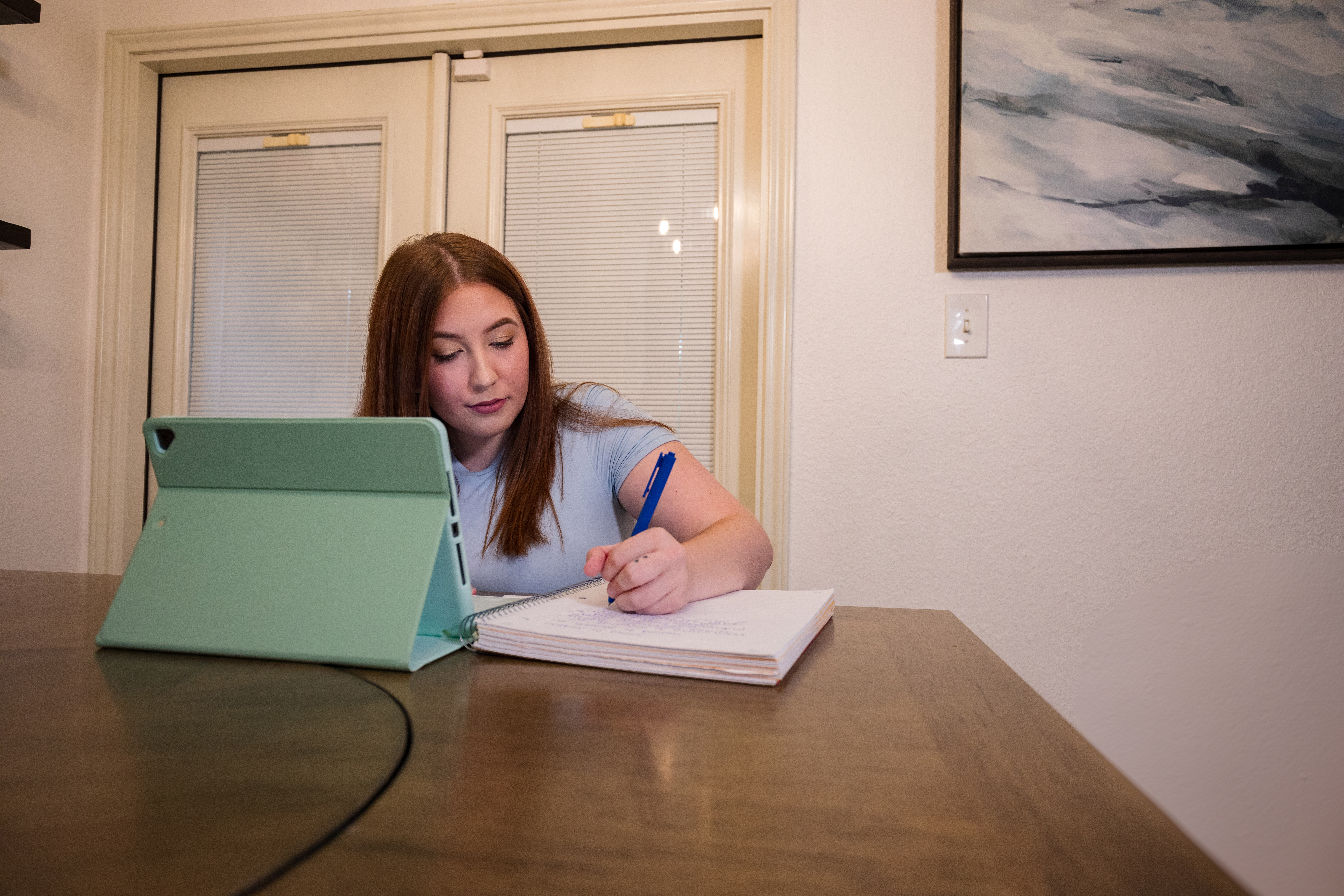 Alamo College Online female student taking notes while studying