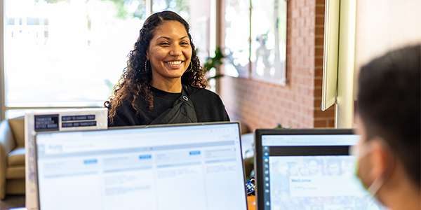 woman smiling at person working on computer