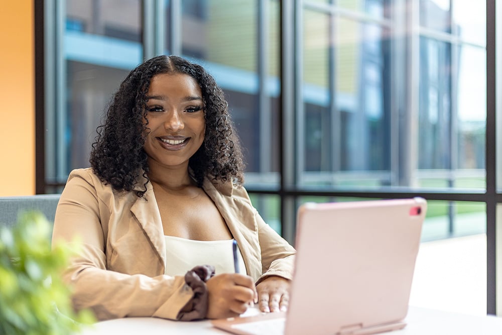 Student Brianna Jones sitting in front of a laptop and smiling